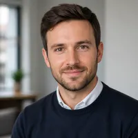 Neutral-looking professional author portrait for NV Casino website. The person is mid-aged, wearing smart casual attire, with